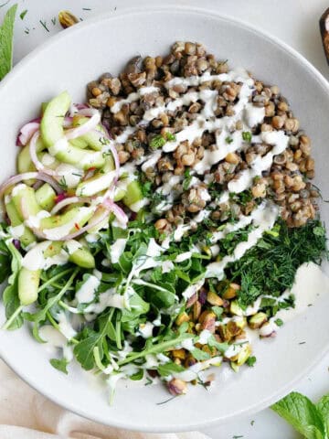 A large lentil bowl bowl packed with veggies topped with homemade dressing.