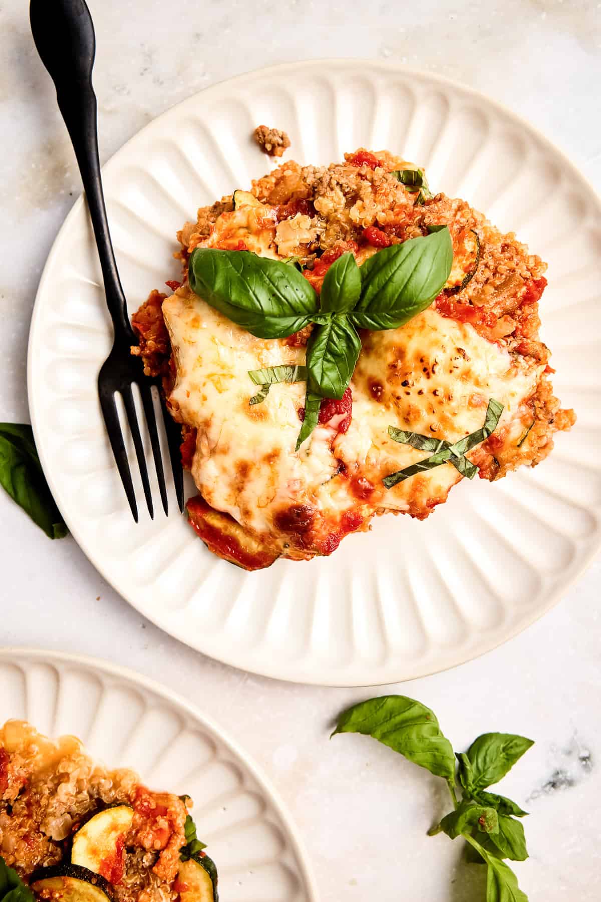 Ground beef, quinoa, and zucchini casserole on a plate with a fork.
