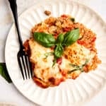 Ground beef, quinoa, and zucchini casserole on a plate with a fork.
