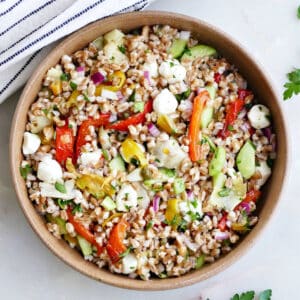 A bowl of Italian farro salad with Mediterranean veggies garnished with parsley.