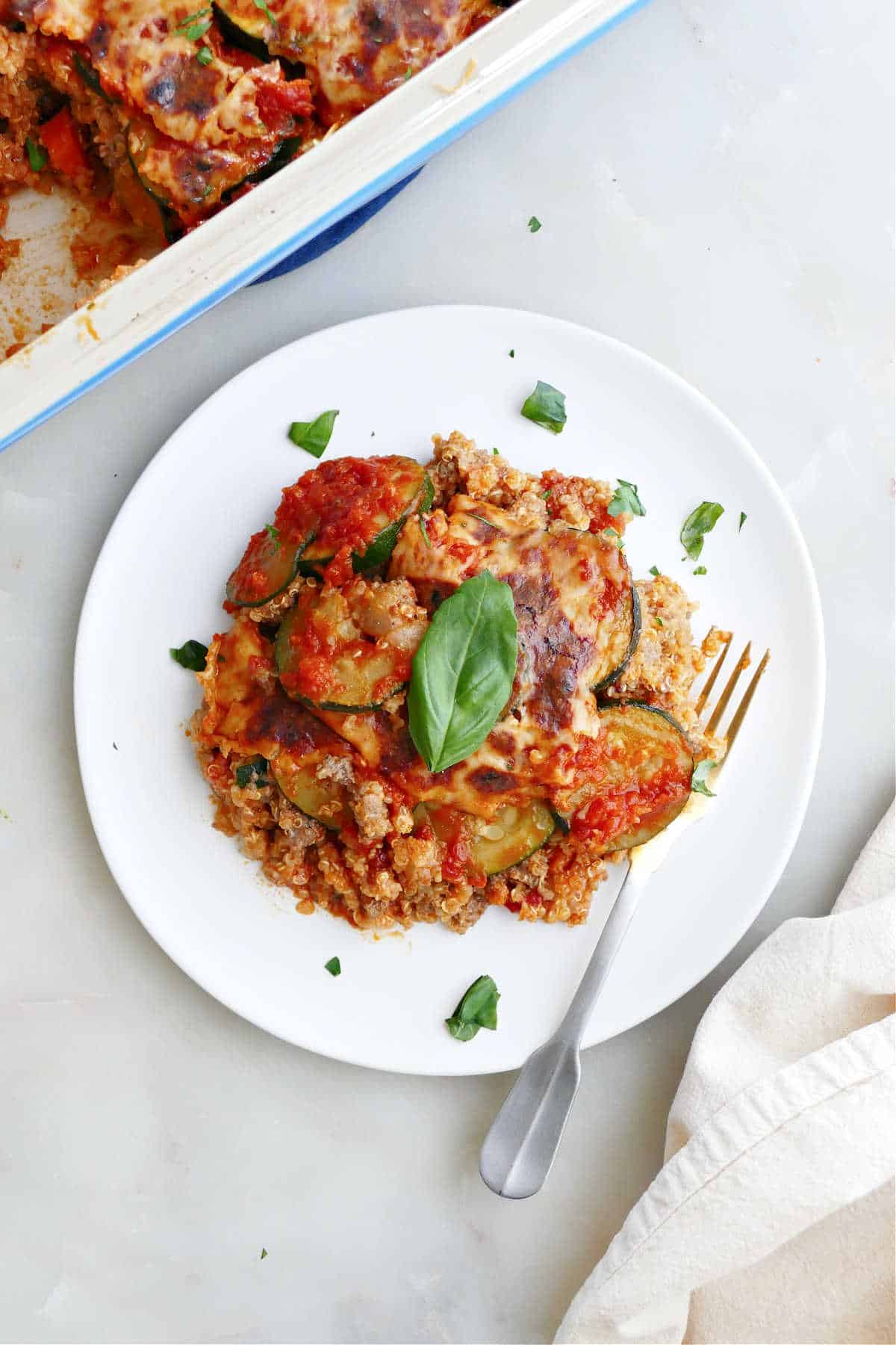Healthy ground beef casserole on a white plate with a fork.
