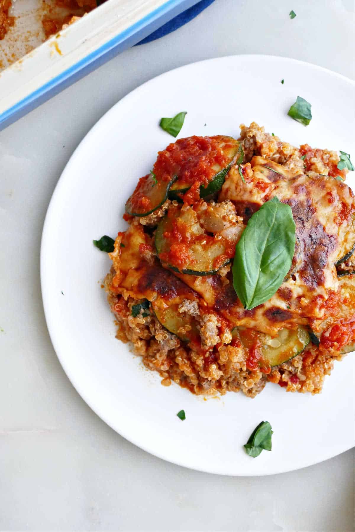 A serving of zucchini hamburger casserole on a white plate.