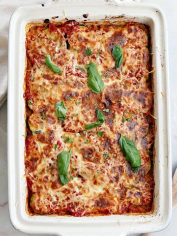 Healthy ground beef casserole made with zucchini in the dish after baking, garnished with basil.