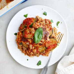 A plate of zucchini hamburger casserole next to a fork.