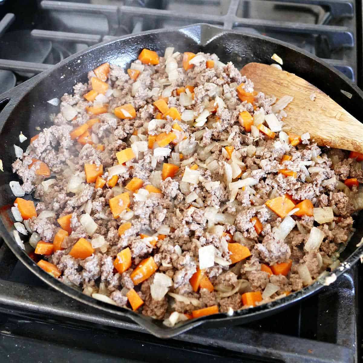 Browning the ground beef for the casserole with onions and carrots.