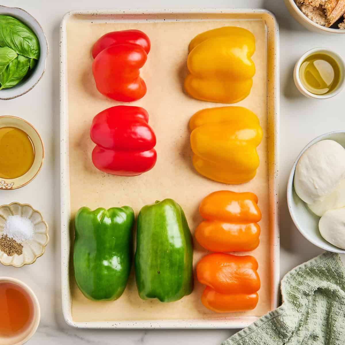 Bell pepper halves cut side down on a baking sheet before going into the oven.