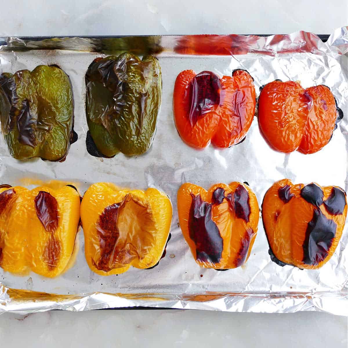 Colorful bell peppers after roasting on a baking sheet.