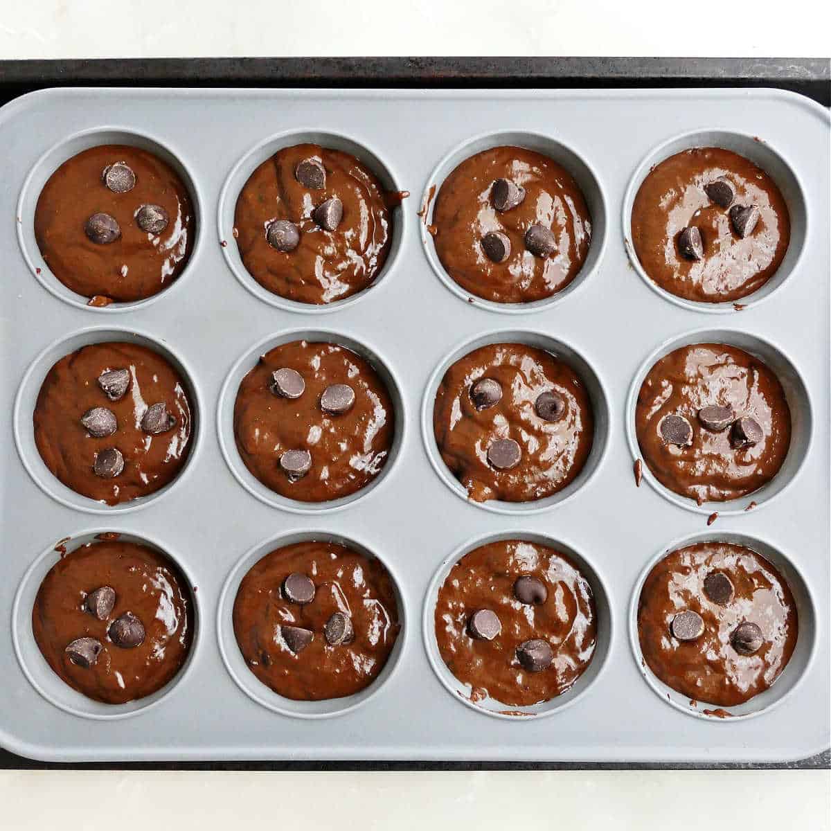 Silicone muffin tray filled with chocolate muffin batter before baking.