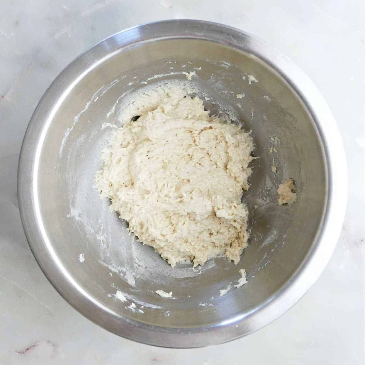 Dough for dumplings for soup mixed together in a bowl on a counter.