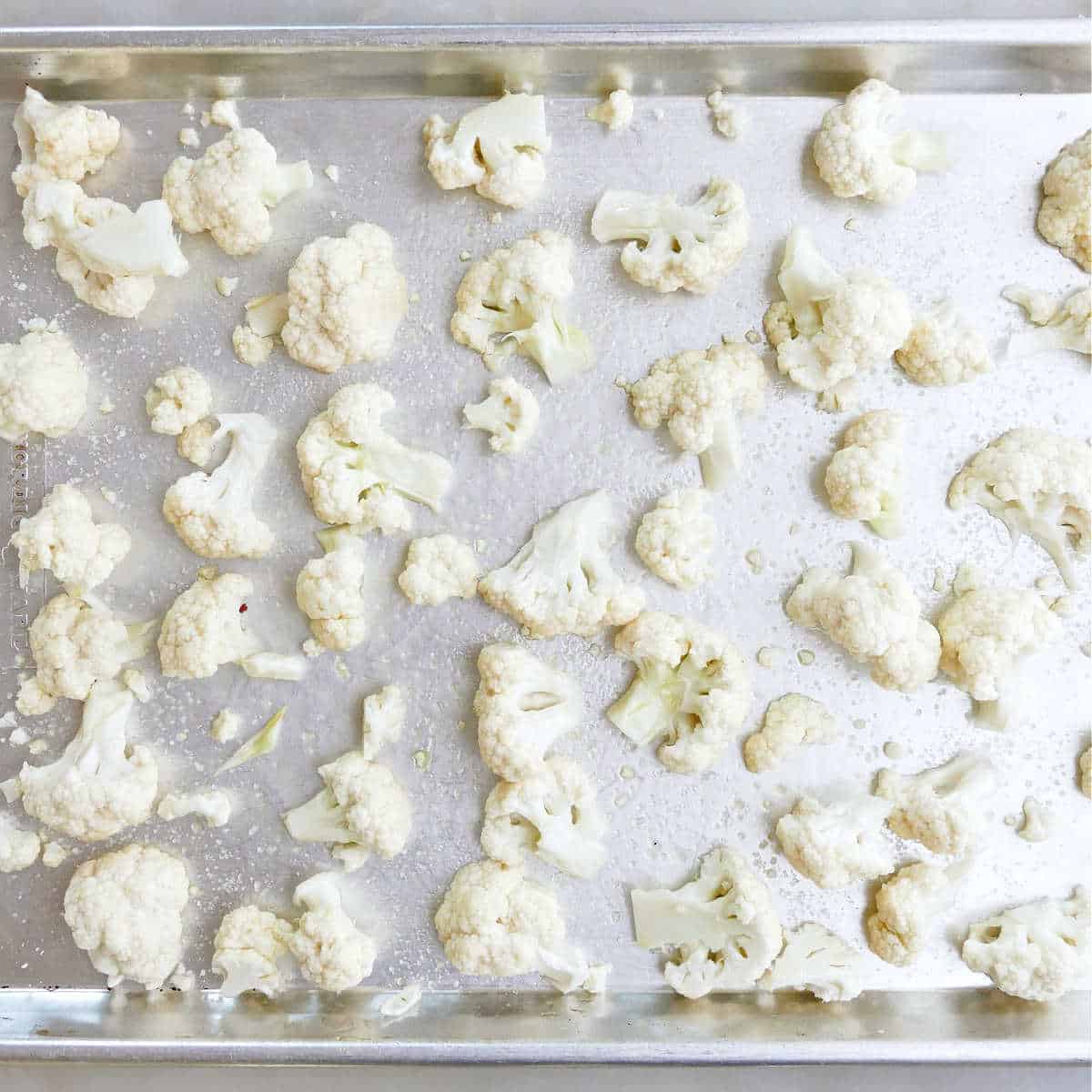 Raw cauliflower on a baking sheet before roasting.