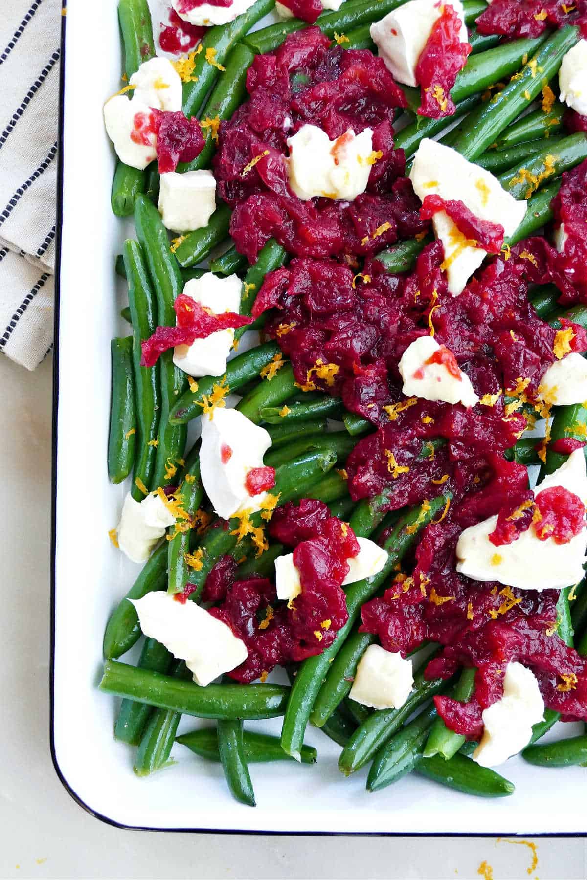 Cranberry green beans with brie and garnished with orange zest.