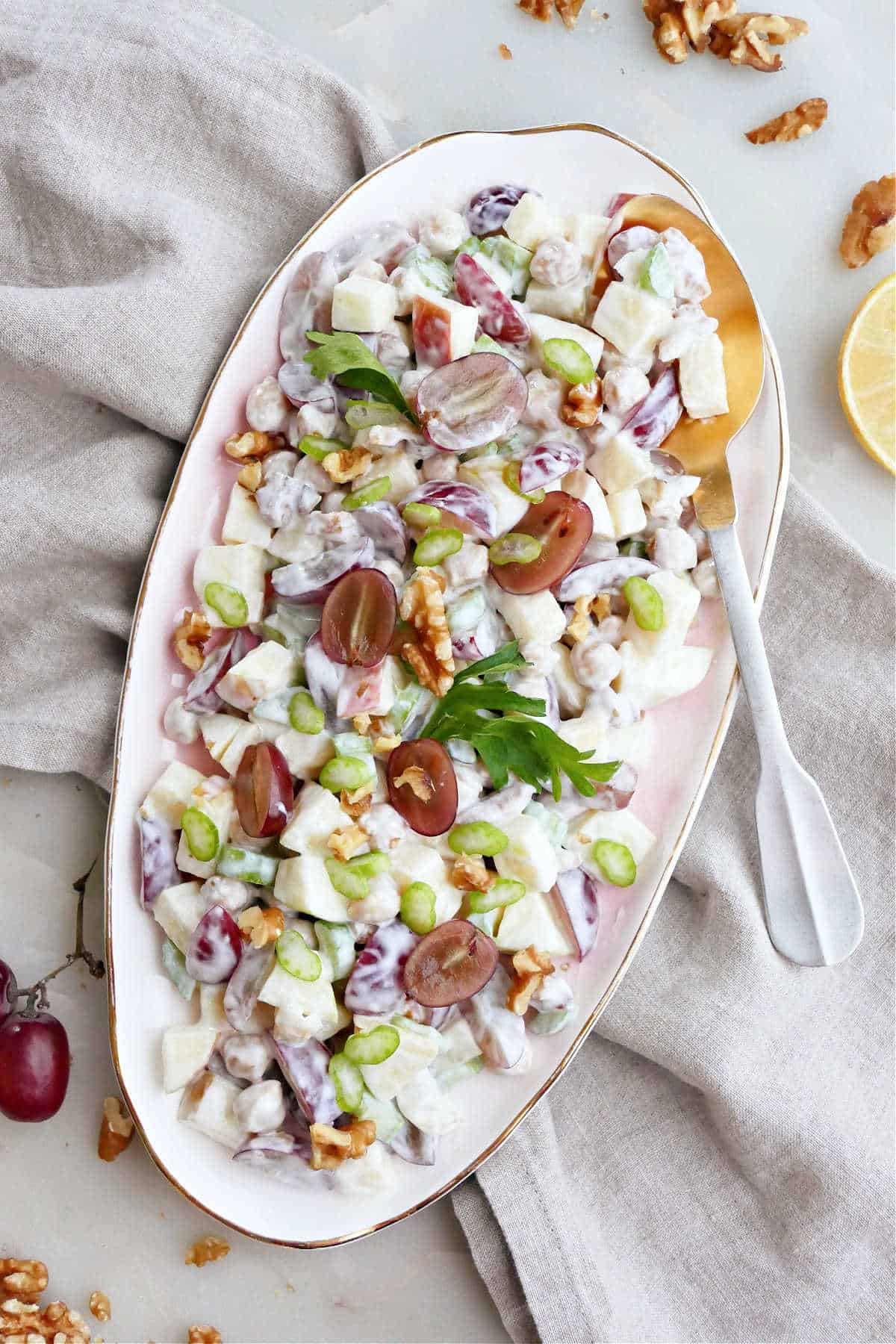 Healthy waldorf salad in a large serving bowl with a spoon.