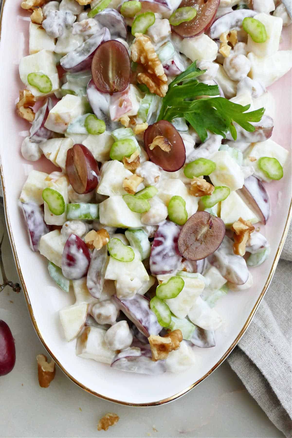 Chickpea waldorf salad in a serving bowl topped with garnish.