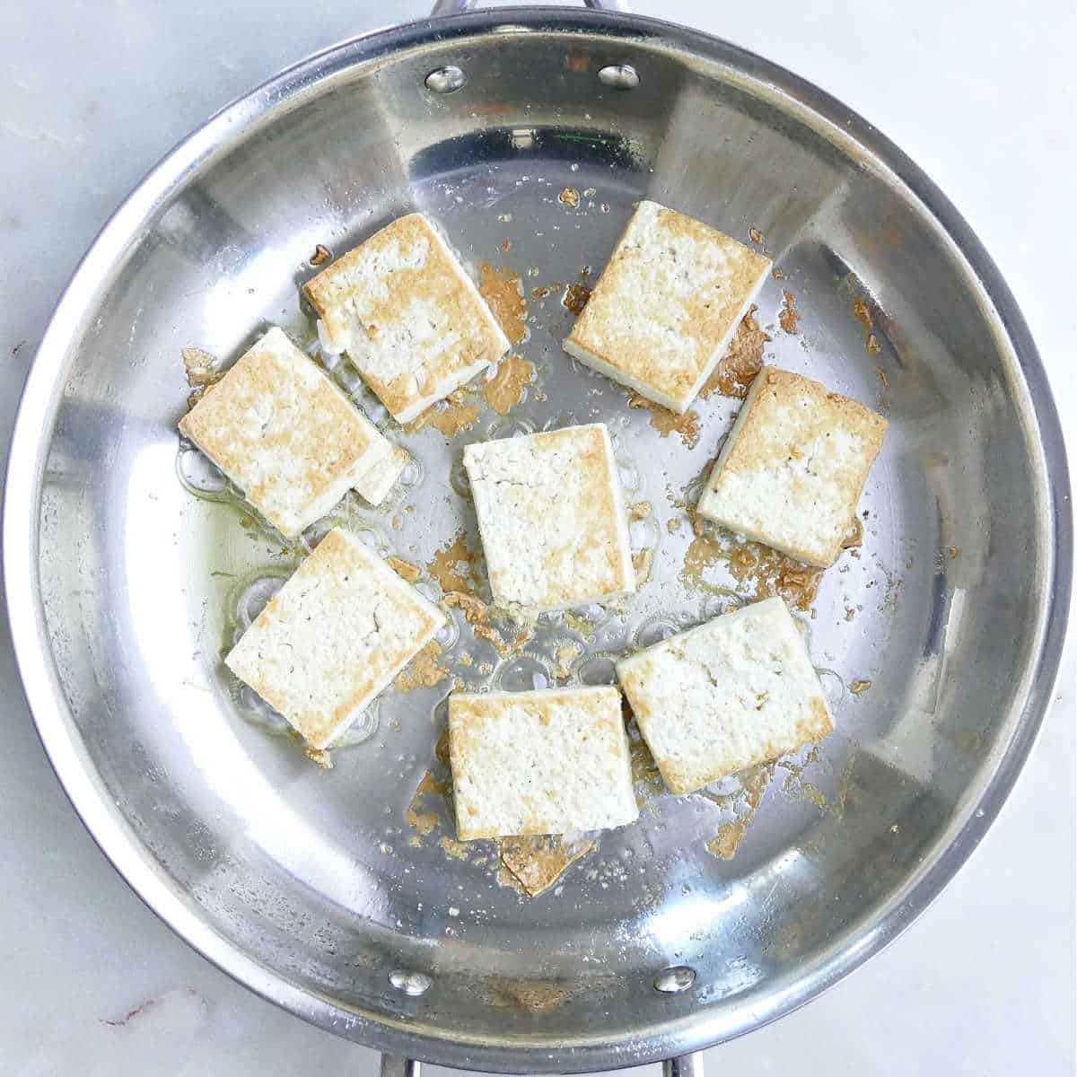 Browning the tofu in a large skillet.