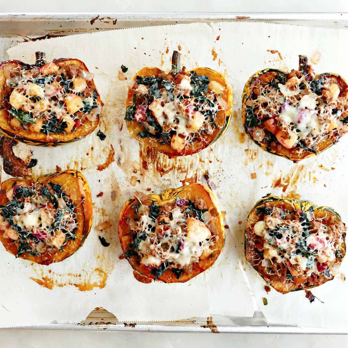 Finished stuffed squash with melted cheese on top on a baking sheet.