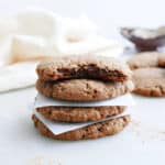 Almond flour cookies stacked on top of each other with a bite taken out of the top one.