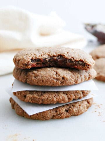 Almond flour cookies stacked on top of each other with a bite taken out of the top one.