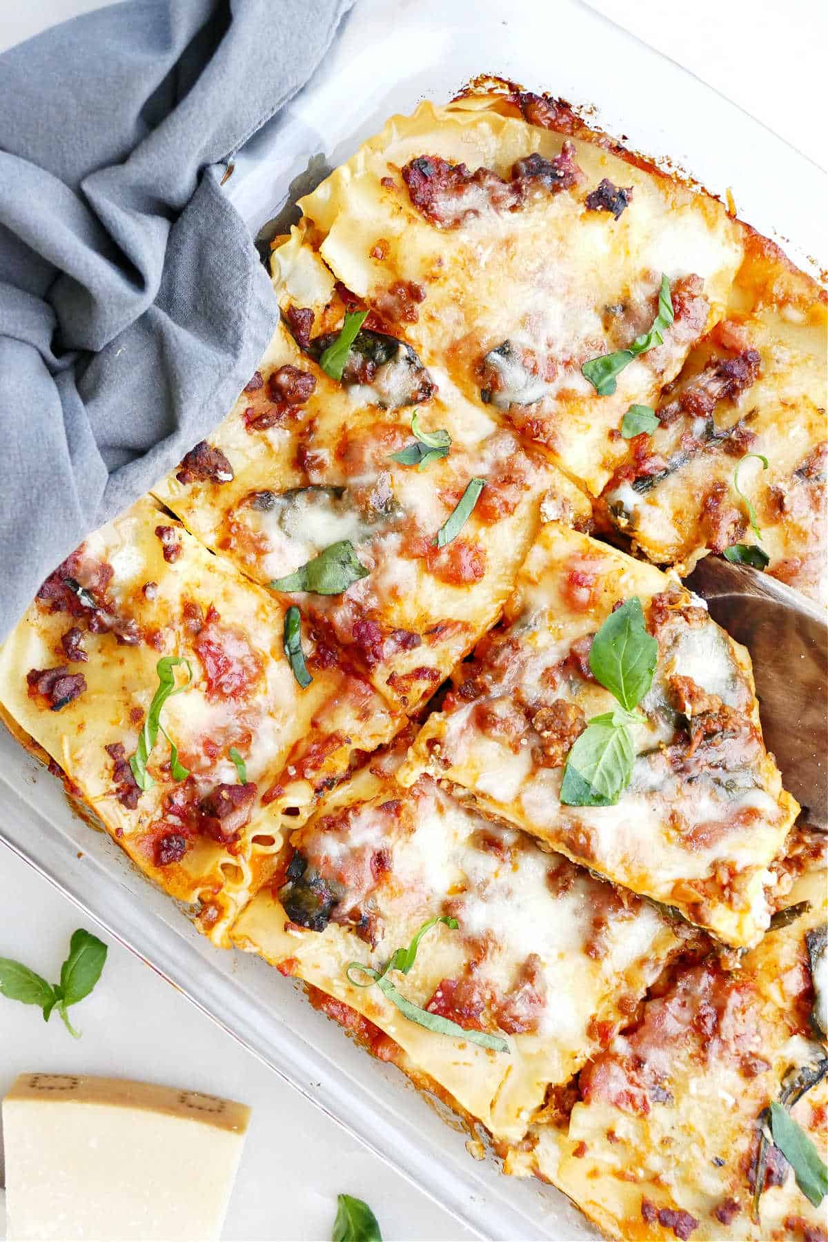 Tray of beef veggie lasagna next to a napkin and garnishes.