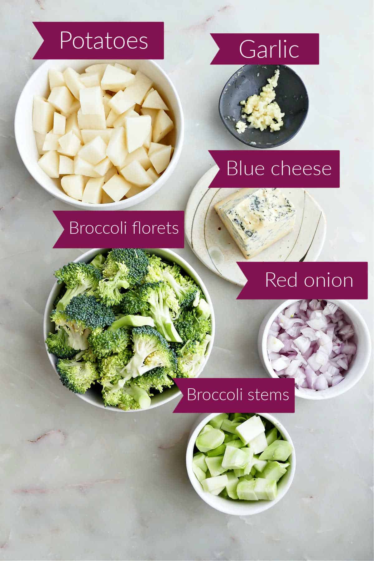 Ingredients for broccoli soup in bowls on a counter with labels.