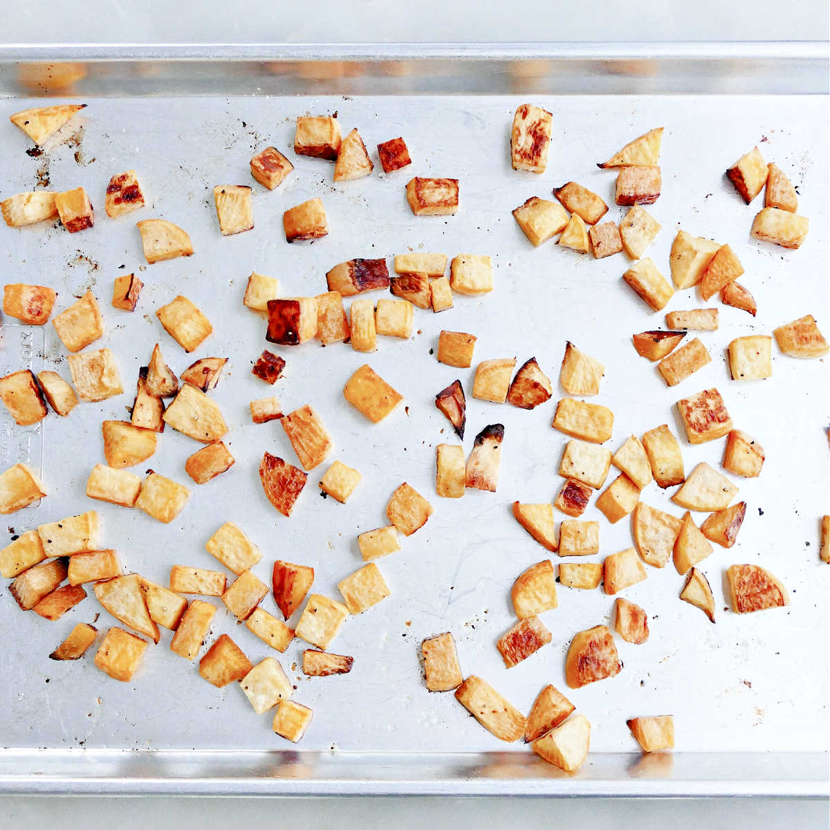 Rutabaga cubes on a baking sheet after being baked in the oven.