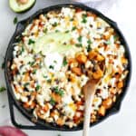 Easy sweet potato dinner in a cast iron skillet with a wooden spoon.