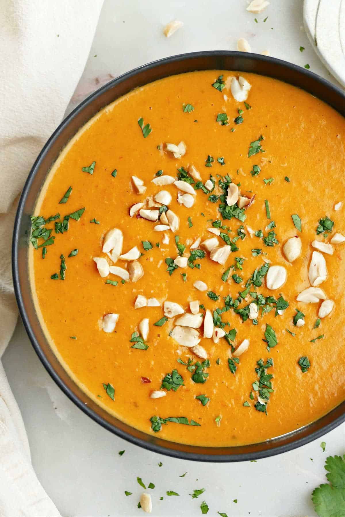 Roasted red pepper sweet potato soup with toppings in a bowl.