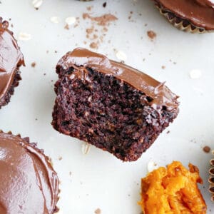 Chocolate cupcake with bite taken out of it next to spoon of sweet potato.