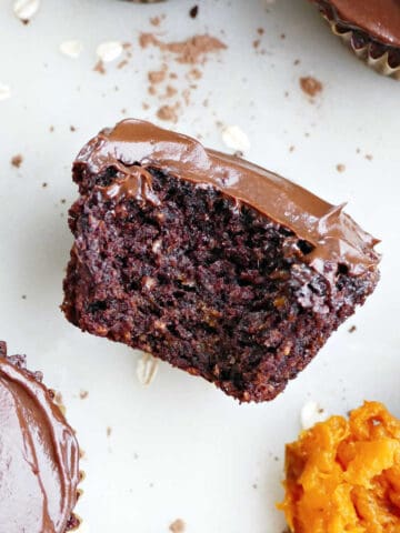 Chocolate cupcake with bite taken out of it next to spoon of sweet potato.