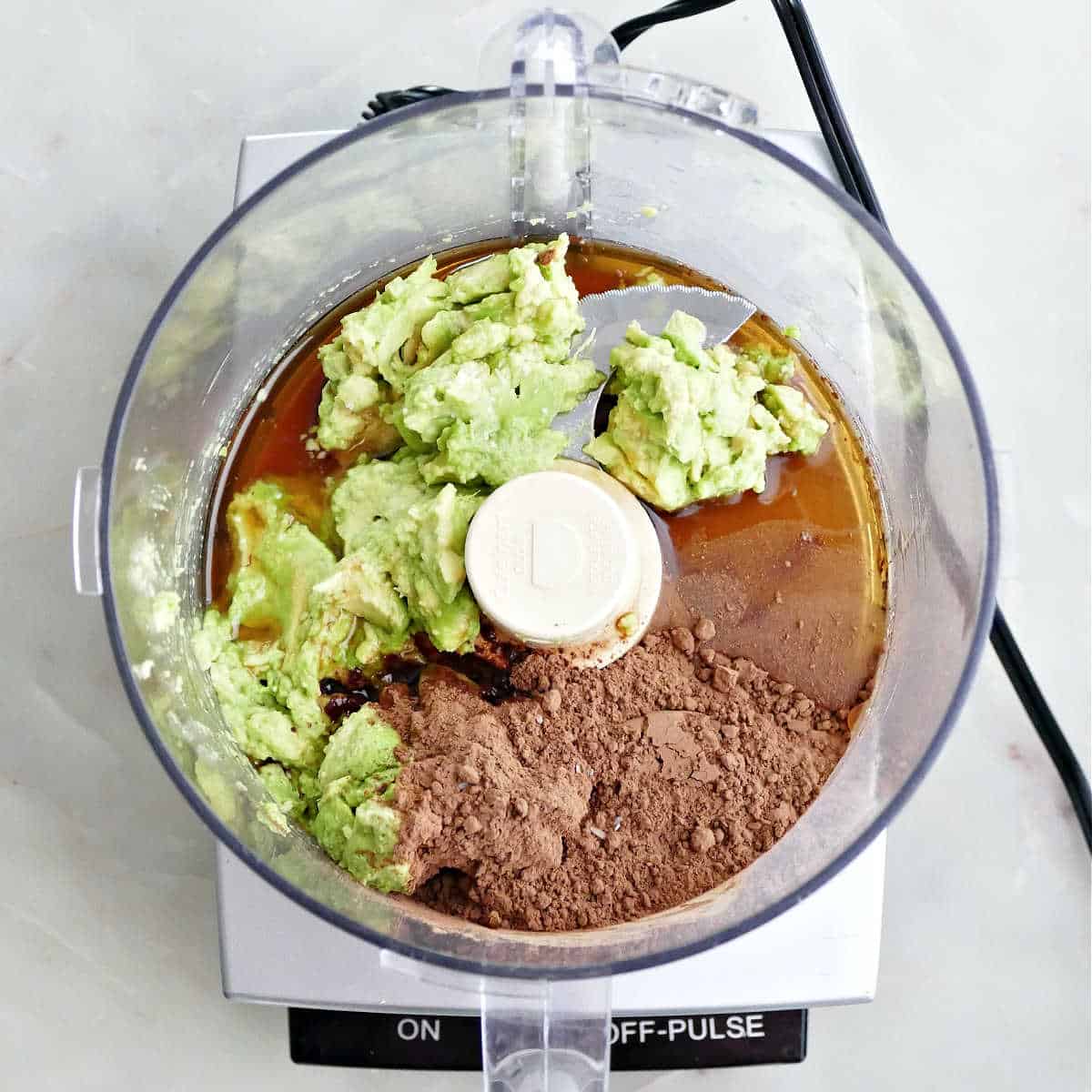 Avocado flesh, cocoa powder, maple syrup, and vanilla extract in a food processor.