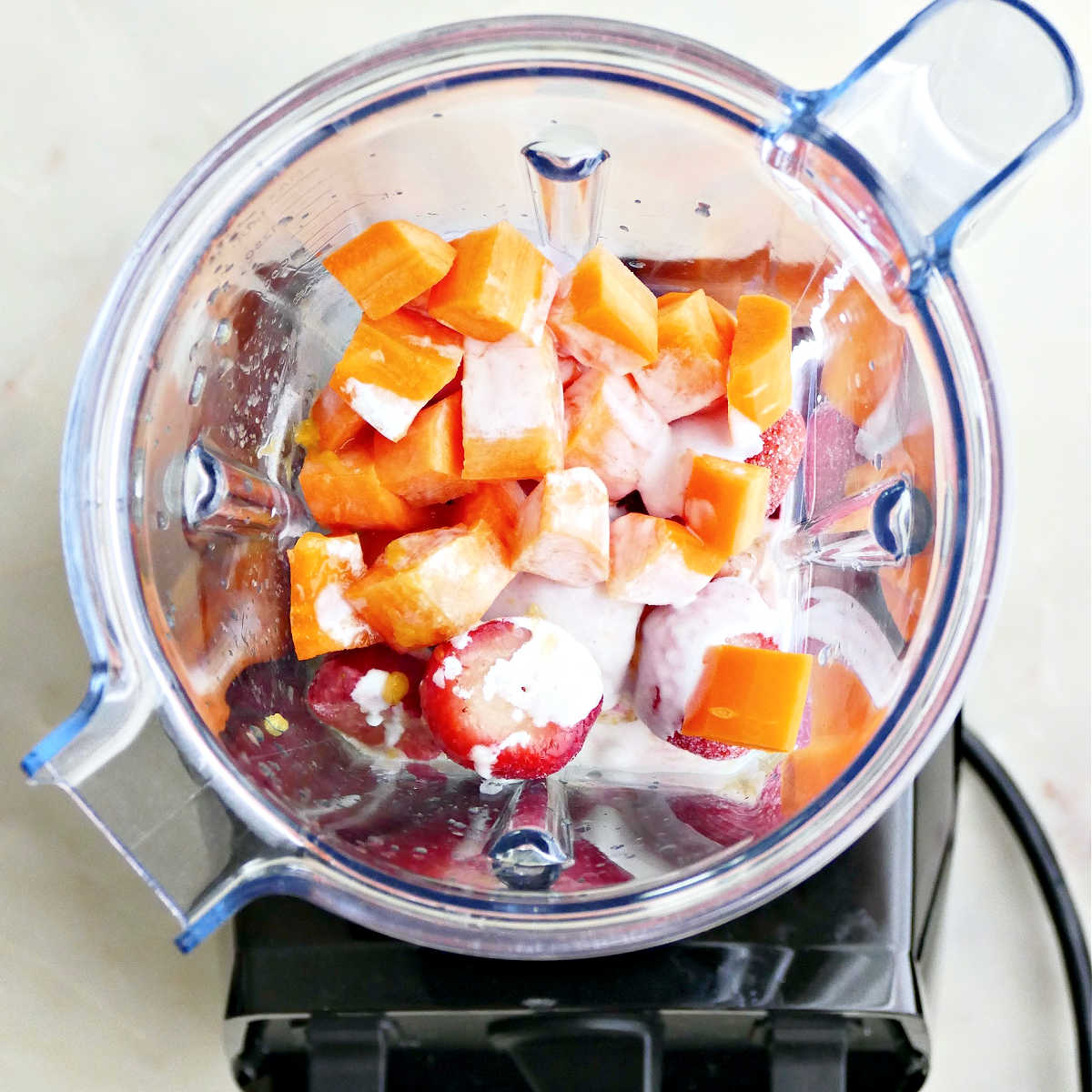 Ingredients for a smoothie in a Vitamix blender before blending.