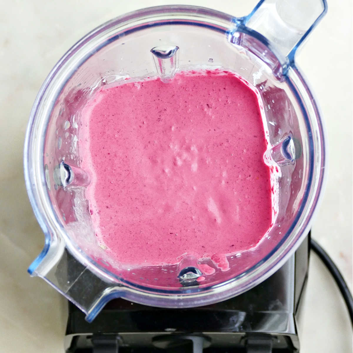 Blended beet carrot smoothie in a Vitamix on a counter.