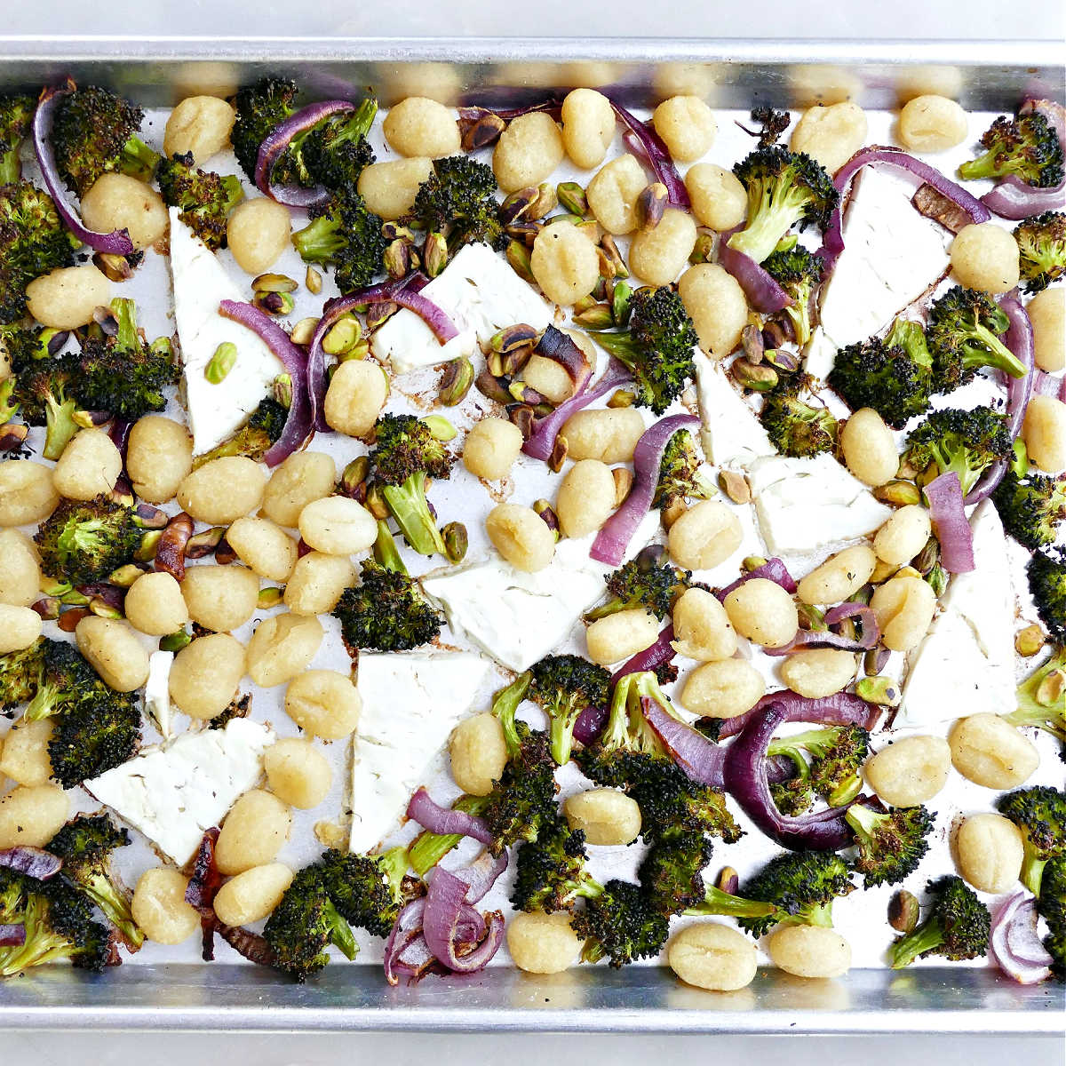 Baked feta gnocchi with vegetables on a sheet pan.