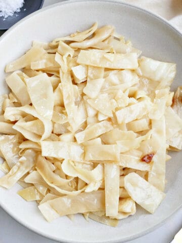 Slow cooker cabbage in a serving bowl on a counter.