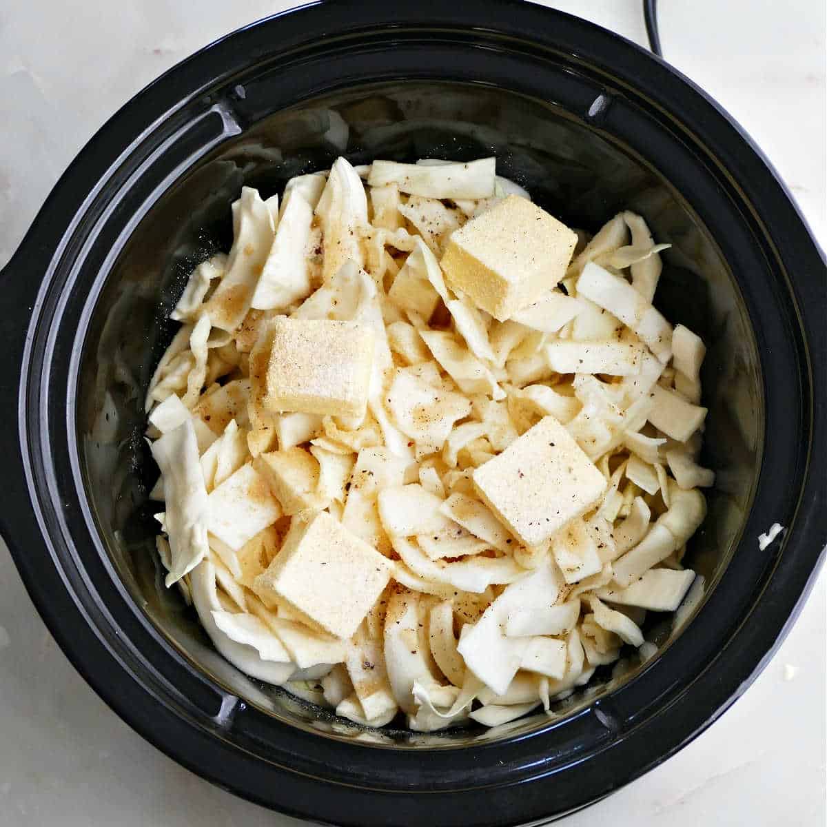 Ingredients for crock pot cabbage in the slow cooker before cooking.