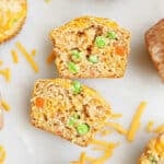 A savory muffin with vegetables cut in half, cut side up, on a counter.