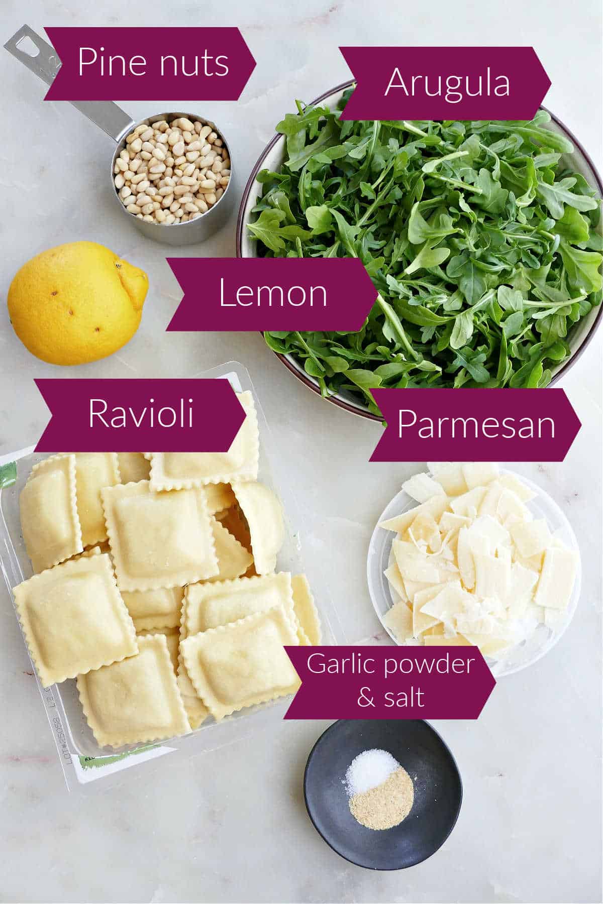 Ingredients for ravioli pasta salad with labels on a counter.