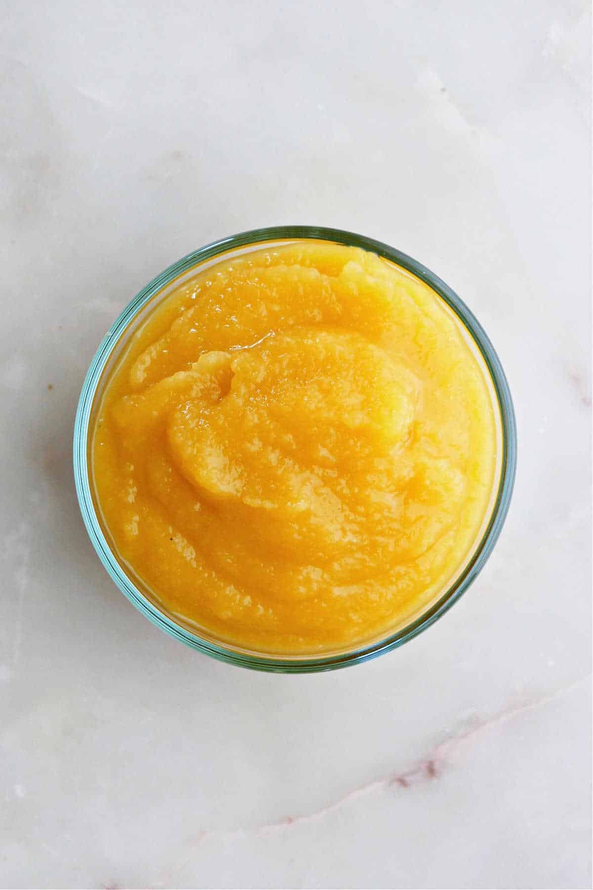 Top view of mashed acorn squash puree in a glass bowl. 