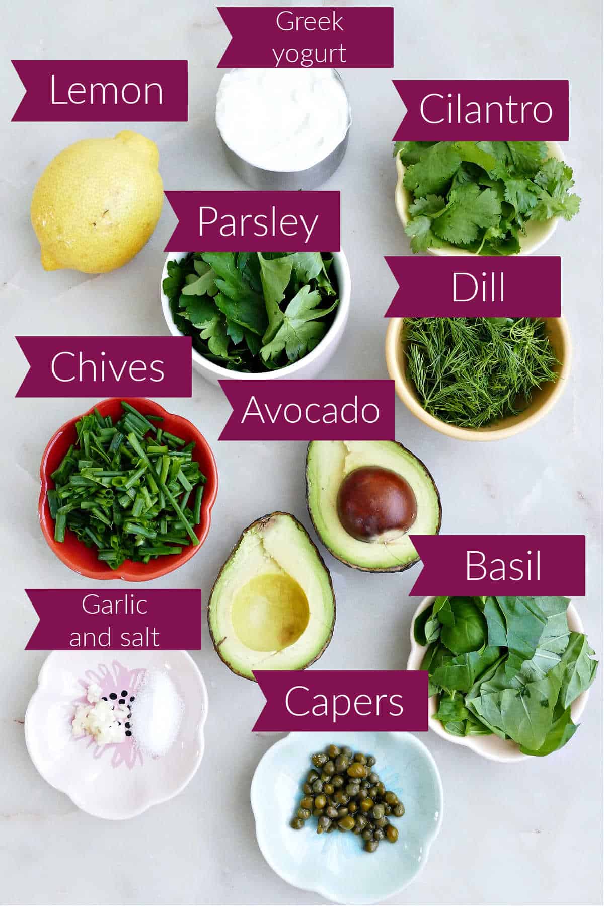 Lemon, Greek yogurt, fresh herbs, avocado, garlic, salt, and capers on a counter with labels.