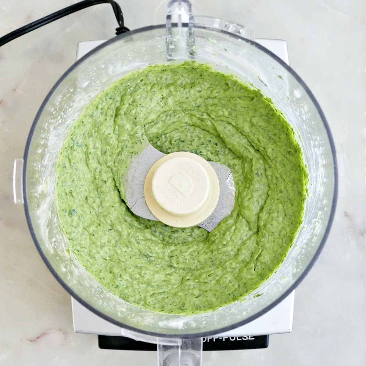 Avocado green goddess dressing blended in a food processor.