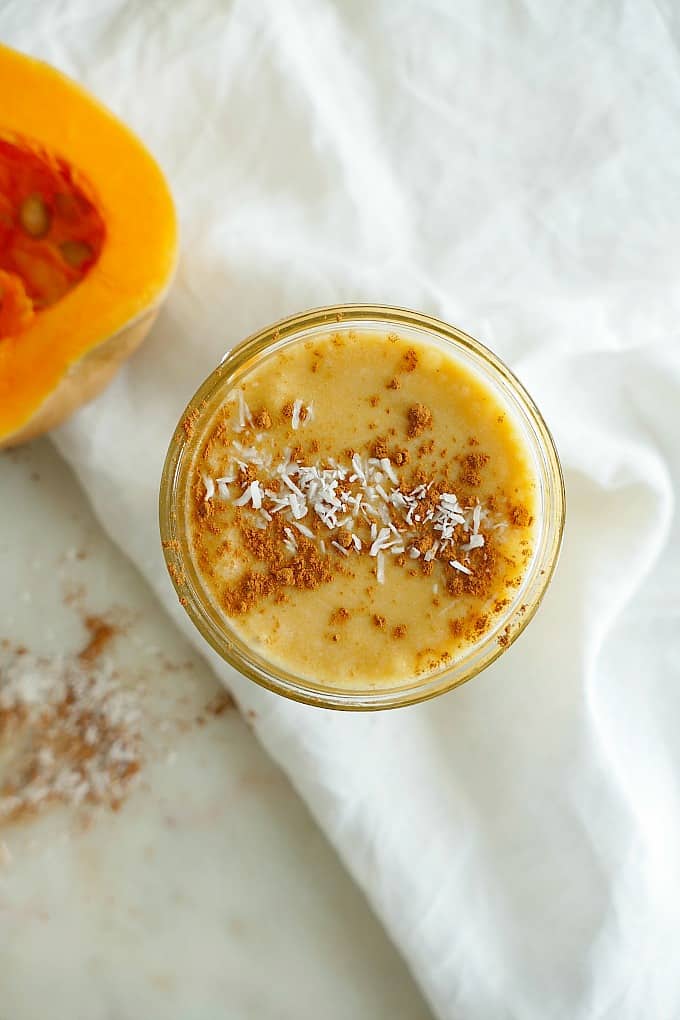 Top view a jar of butternut squash dessert smoothie sprinkled with cinnamon and coconut.