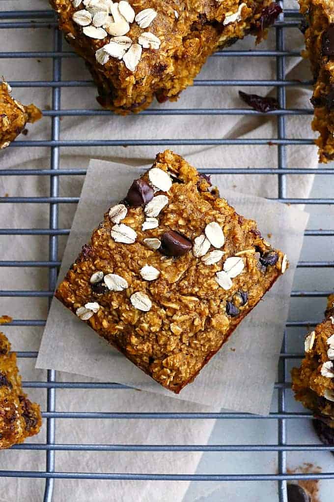A close up of chocolate cherry pumpkin oatmeal bars on a cooking rack. 