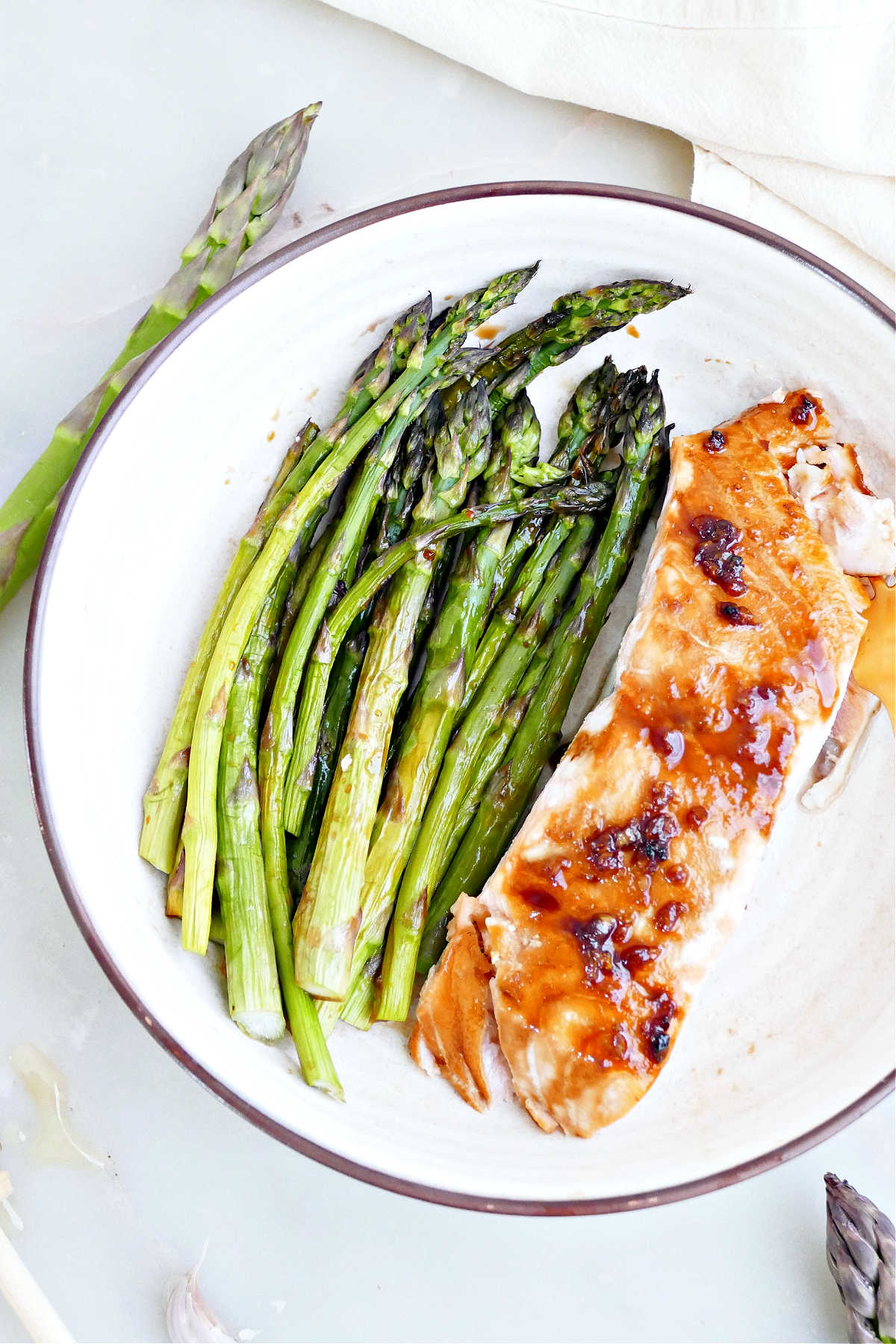 Roasted asparagus and salmon with honey soy glaze on a plate.