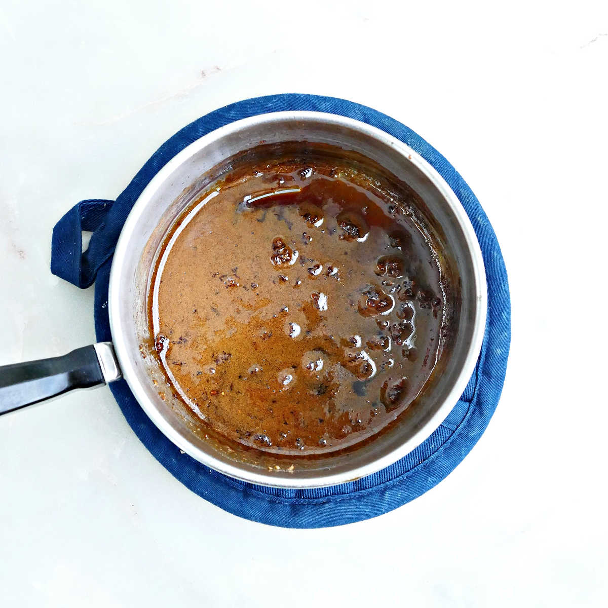 Soy honey glaze in a saucepan after being cooked until thickened.