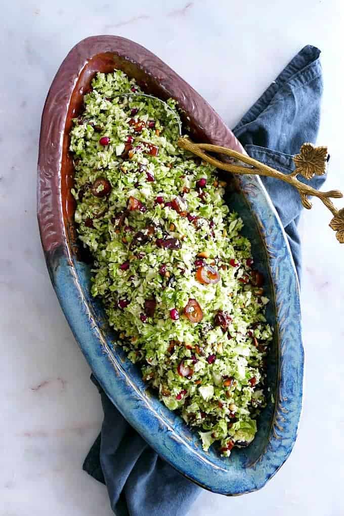 Shredded Brussels Sprouts Salad with Dates in a unique oval dish.