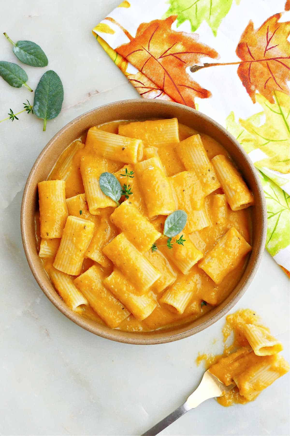 Butternut Squash Mac and Cheese next to a fall dish towel and fork. 
