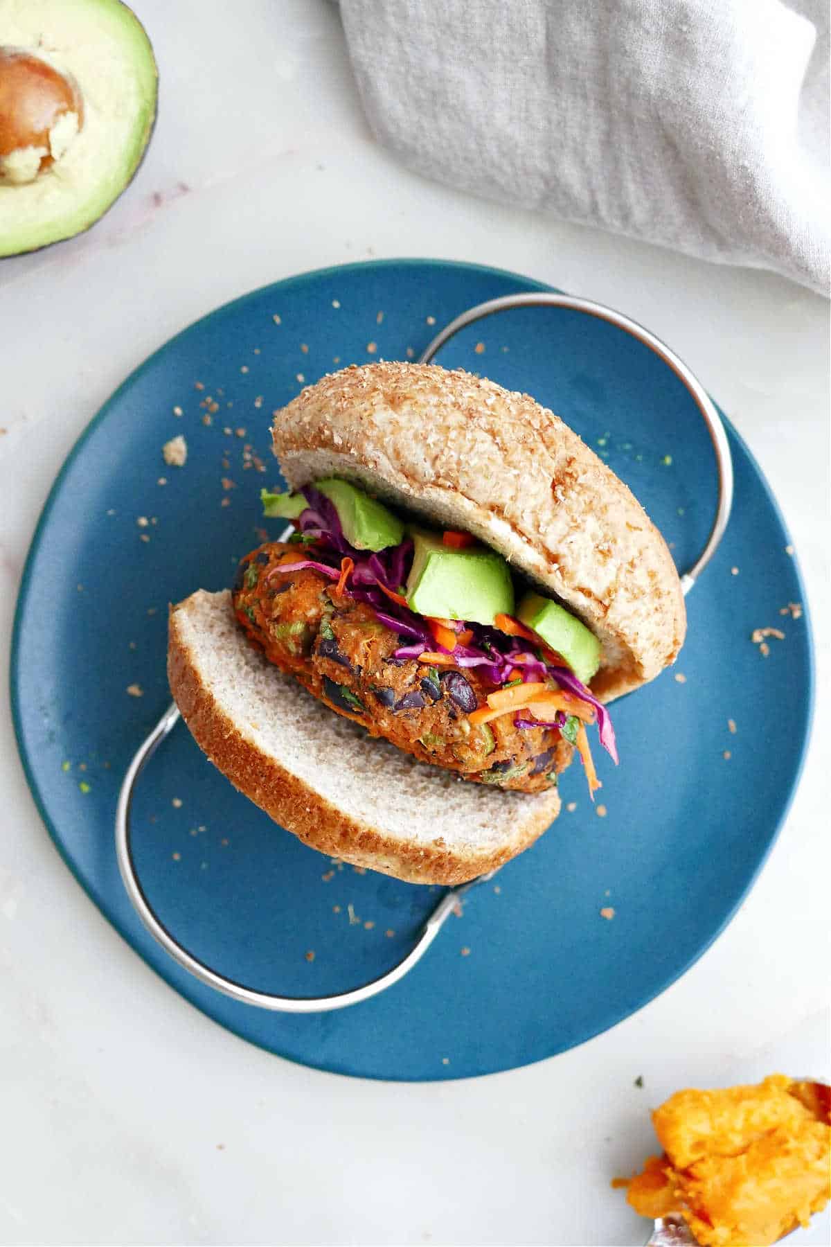 A black bean and sweet potato veggie burger on a blue plate.