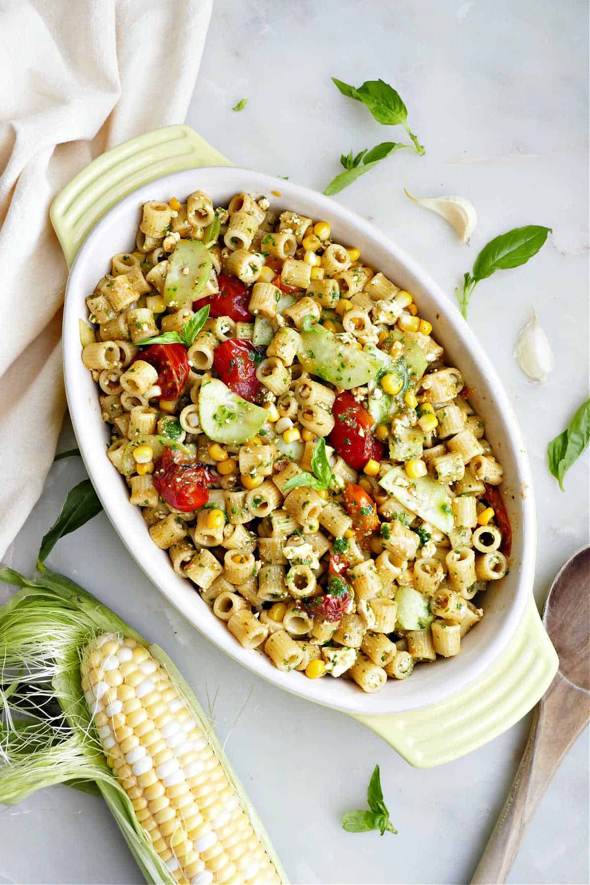 Ditalini pasta salad with summer vegetables in a yellow oval serving dish.