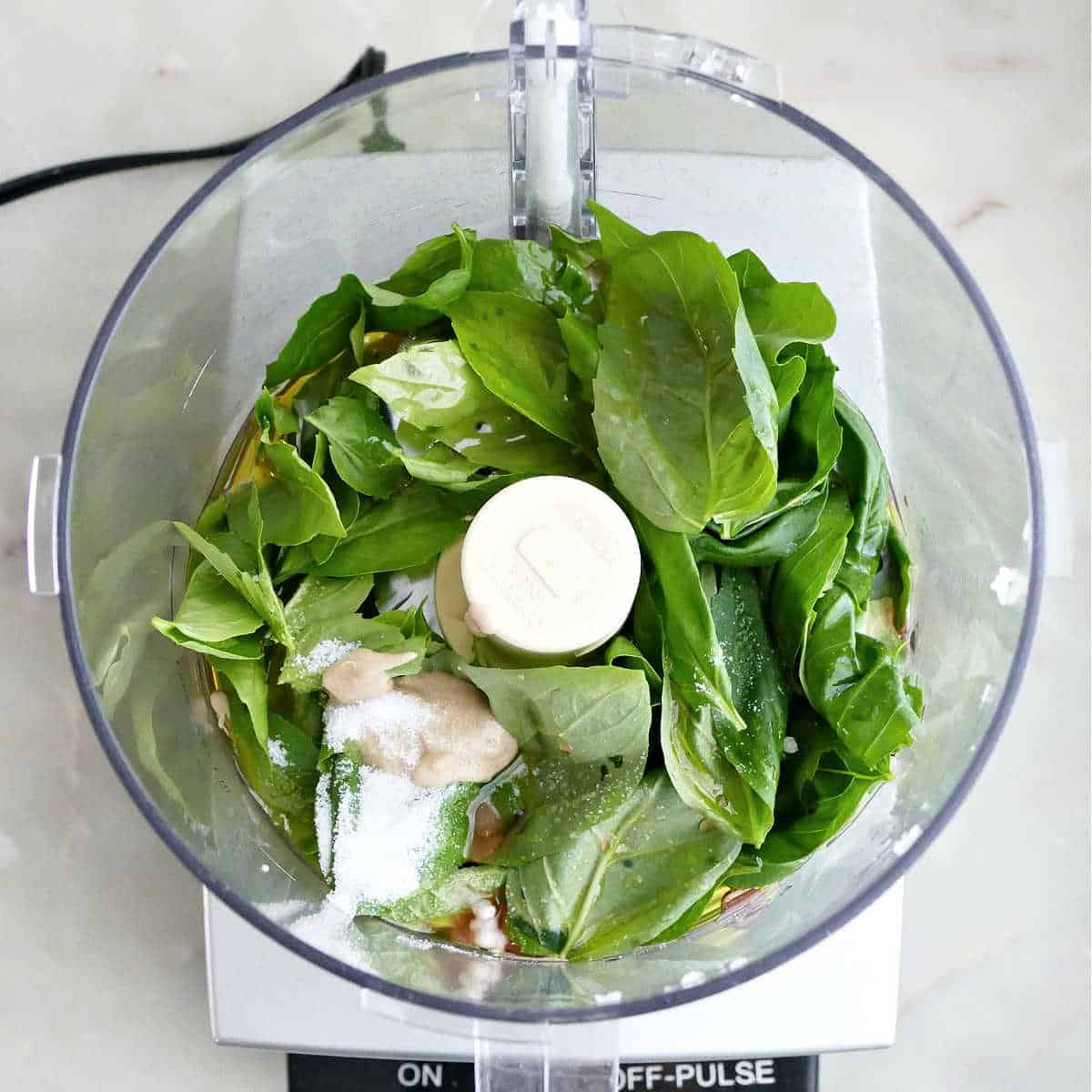 Basil, salt, minced garlic, oil, vinegar, and mustard in a food processor.