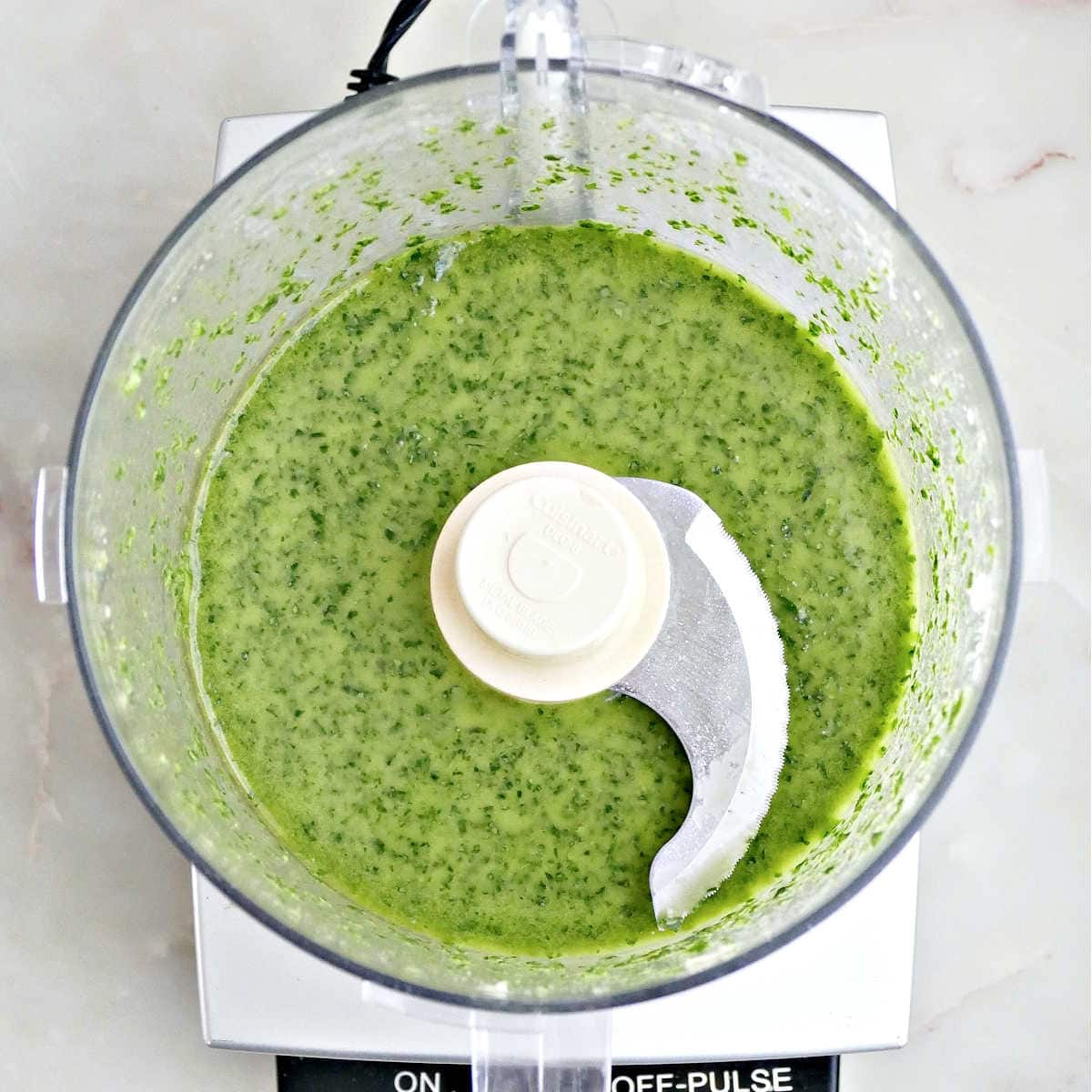 Ingredients for basil vinaigrette pulsed into a dressing in a food processor.