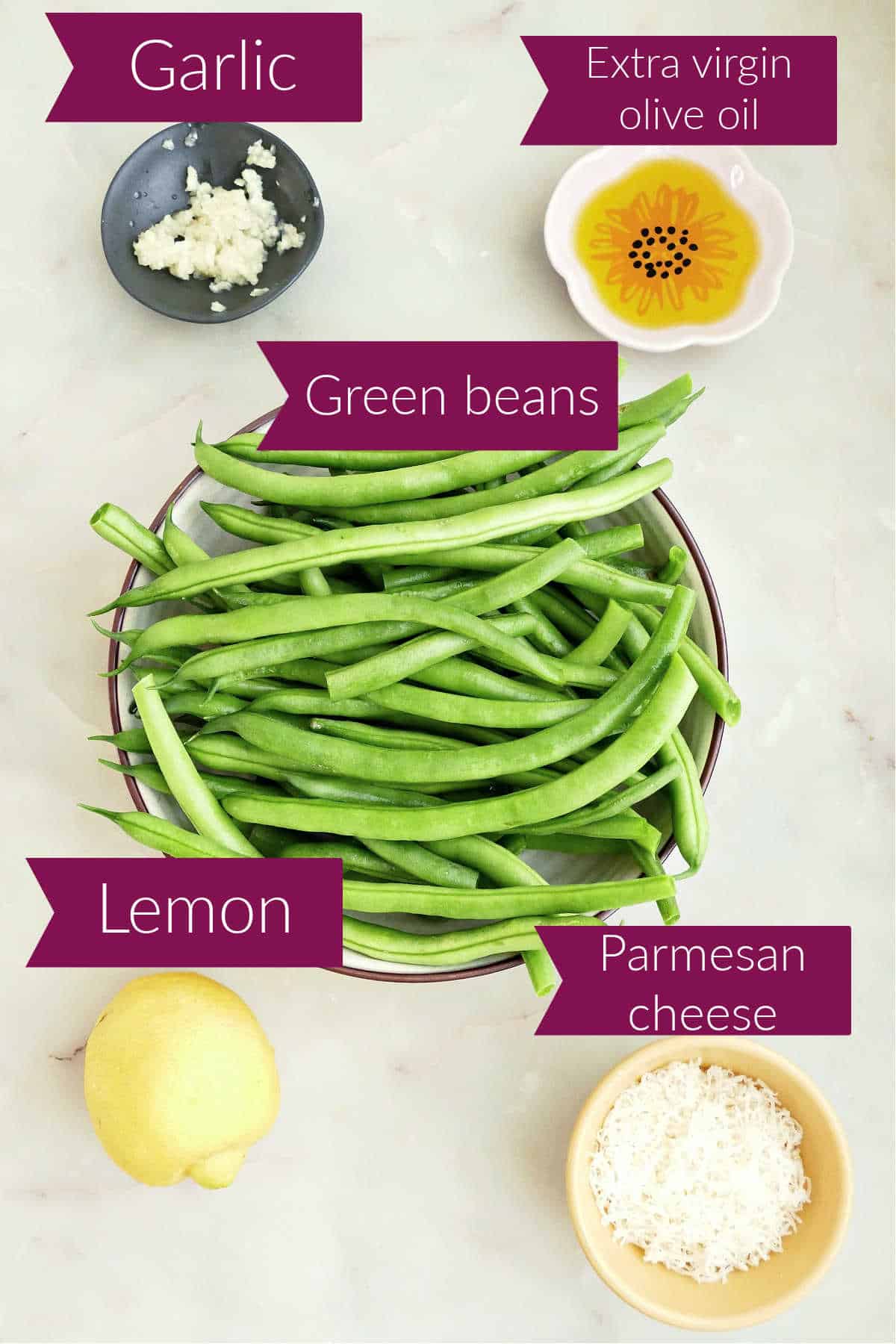 Garlic, olive oil, green beans, lemon, and parmesan on a counter with labels.